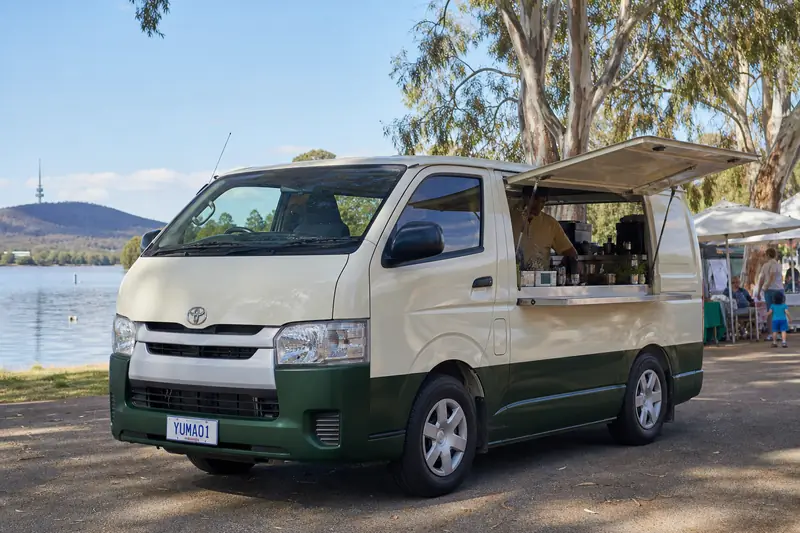 Yuma Book brand artwork of a coffee van beside Lake Burley Griffin